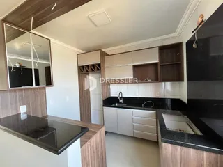 Uma cozinha moderna com armários de madeira e bancadas escuras.