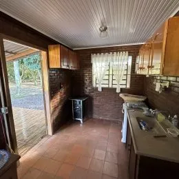 Ambiente interno com revestimento de madeira nas paredes e teto de painéis.