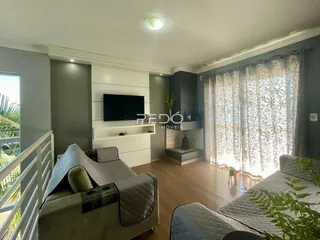 Sala de estar com sofá e televisão em um apartamento.