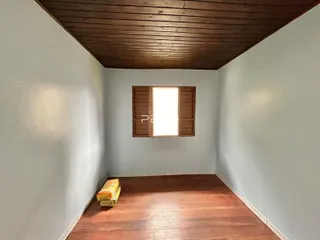 Vista interna de um cômodo com piso de madeira e teto de madeira.