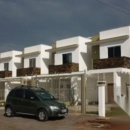Fachada de uma casa moderna em Lajeado, Brasil, com cerca e veículo estacionado na frente.