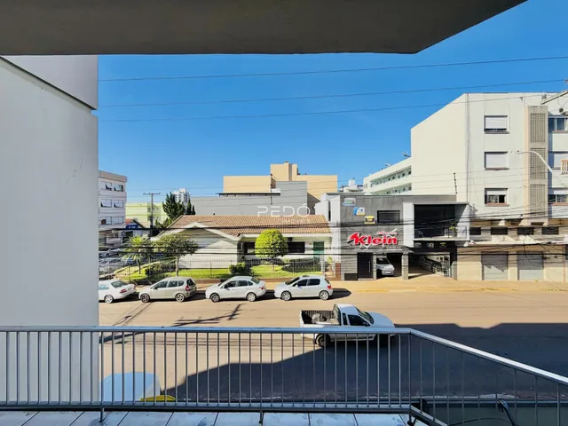 Vista externa de uma rua com carros estacionados em frente a uma residência.