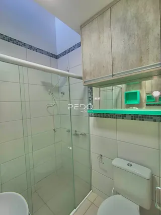 Foto de um banheiro com box de vidro e vaso sanitário.