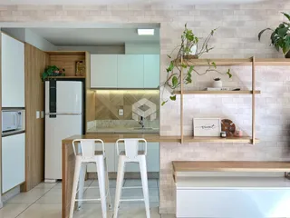 Vista de uma cozinha moderna com armários de madeira e paredes de tijolo.