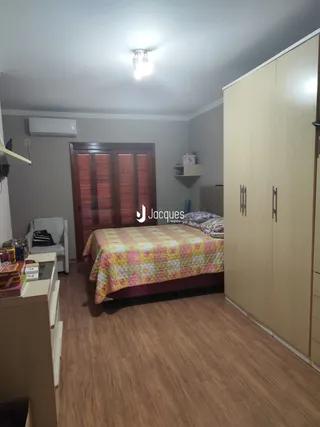 Quarto com cama e armário de madeira no imóvel.