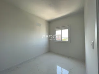 Ambiente interno com paredes brancas e piso de cerâmica claro.