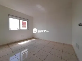 Sala de estar com piso de cerâmica e janela clara.