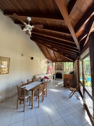 Sala de jantar com pé direito alto e teto de madeira em ambiente residencial.