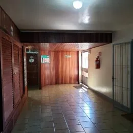 Corredor interno com revestimento de madeira nas paredes.