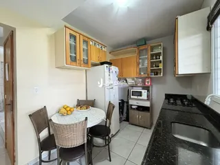 A cozinha e a área de jantar mostram armários de madeira e uma mesa de jantar.