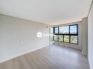 Foto de um cômodo amplo com grandes janelas que oferecem uma vista da paisagem urbana.