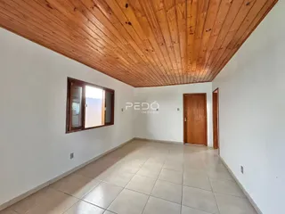 Sala de estar com teto de madeira e piso de cerâmica.