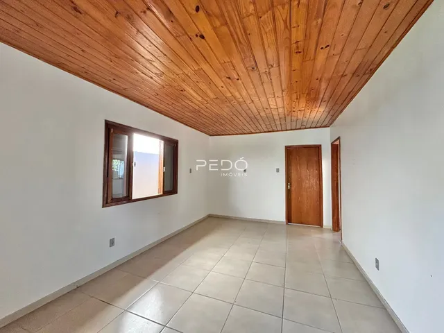 Sala de estar com teto de madeira e piso de cerâmica.