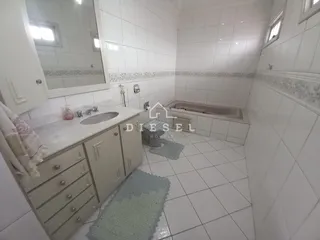 Foto de um banheiro com revestimento cerâmico e bancada de mármore.