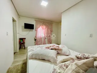 Quarto com cama e cortinas rosa em um imóvel no Brasil.