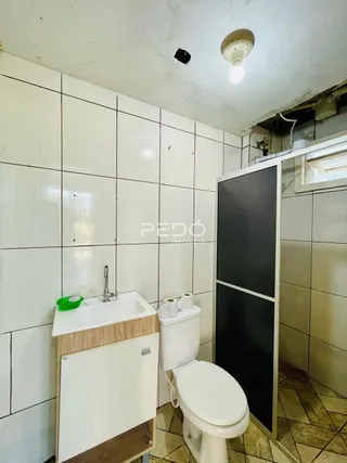 Foto de um banheiro com revestimento cerâmico e vaso sanitário.