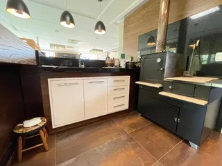 Cozinha moderna com armários escuros e bancadas claras.