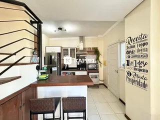 Foto de uma cozinha com bancada de madeira e eletrodomésticos em um apartamento.