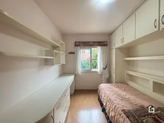 Quarto com armários embutidos e piso de madeira clara.