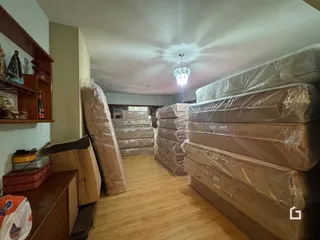 Interior de uma sala com móveis e caixas empilhadas.