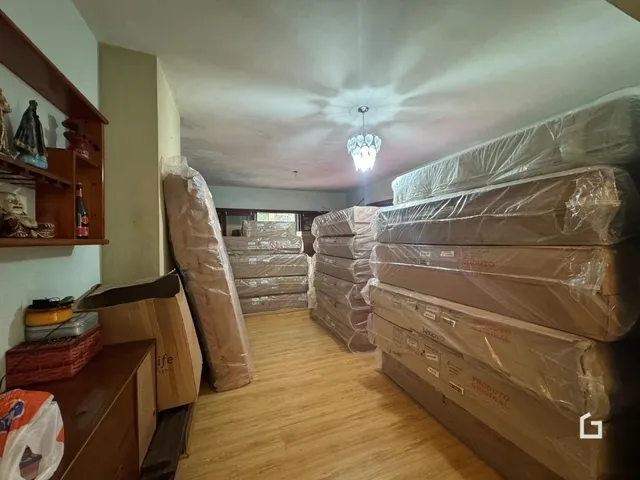 Interior de uma sala com móveis e caixas empilhadas.