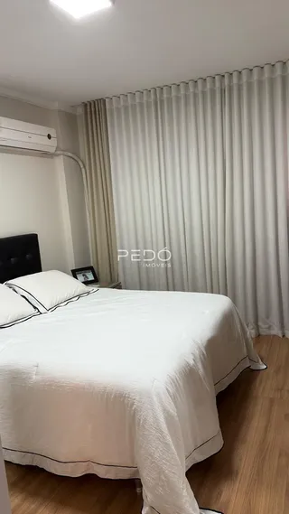 Quarto com cama e cortinas brancas em ambiente interno.