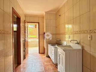Corredor interno com piso de cerâmica e paredes revestidas em azulejos claros.