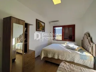 Quarto com armário de madeira e cama.