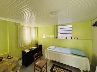 Quarto com paredes verdes e cama de casal.