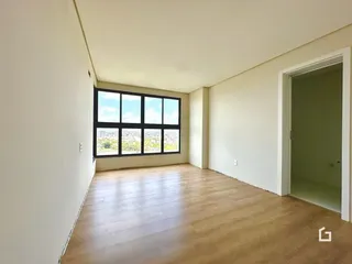 Sala de estar com grande janela oferecendo vista da cidade.