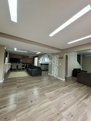 Sala de estar com piso de madeira e ambiente aberto em Lajeado.