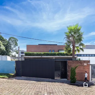 Fachada de uma residência em Lajeado, Brasil, com muro de tijolos e portão.
