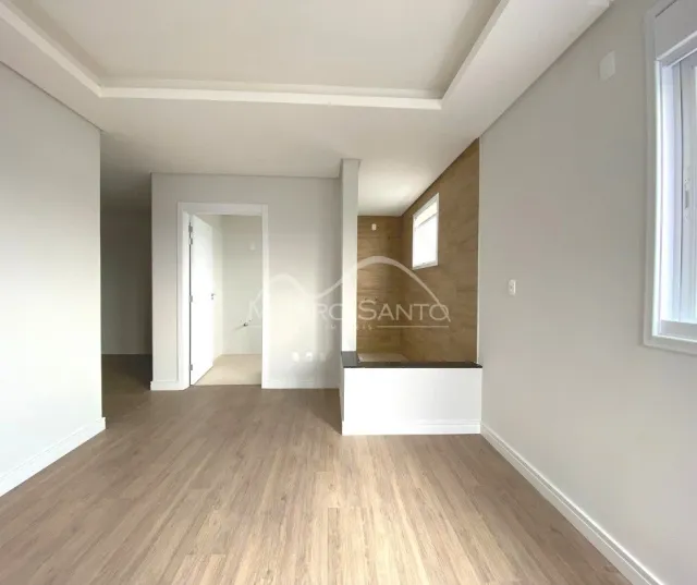 Ambiente interno com piso de madeira clara e paredes brancas em um imóvel.