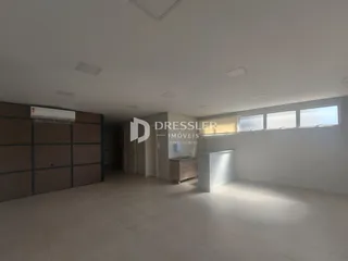Interior de uma sala ampla com armários em madeira e iluminação moderna.