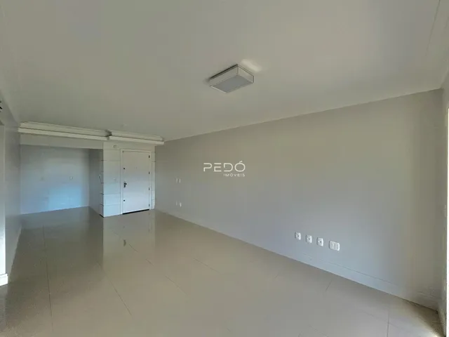 Interior de um corredor amplo com piso claro e paredes brancas.