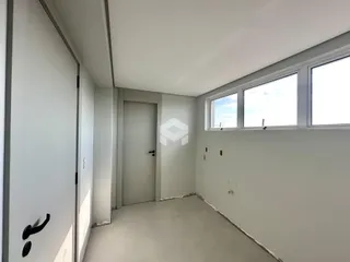 Corredor interno com paredes brancas e piso cinza claro.
