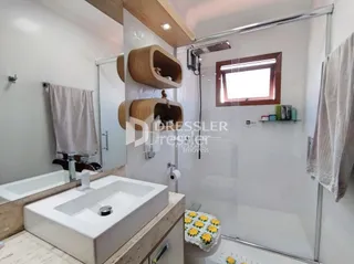 Interior de um banheiro moderno com banheira e box de vidro.