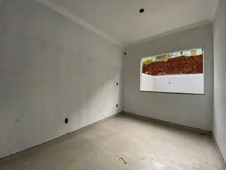 Foto de um cômodo vazio com paredes brancas e piso claro.