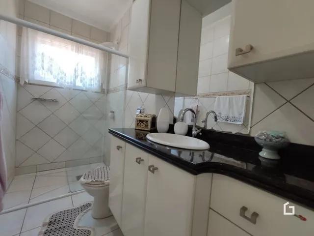 Foto de um banheiro com revestimento de azulejos brancos.