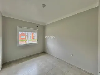 Ambiente interno de uma sala com piso de cerâmica e janela.
