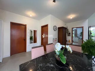 Interior de uma sala de jantar com portas de madeira e mesa de mármore preta.