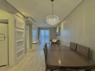 Foto de uma sala de jantar com mesa de madeira e iluminação clara.
