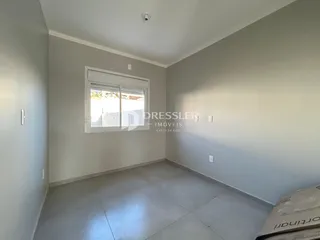 Vista interna de um cômodo com paredes brancas e piso claro.