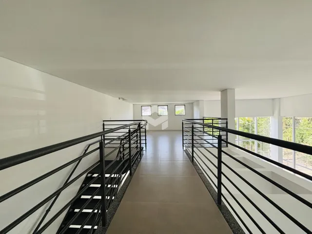 Corredor interno com escadas e paredes brancas.