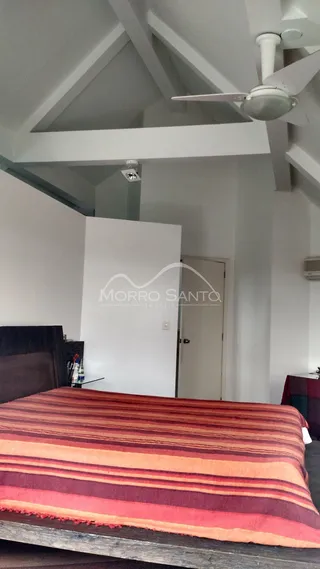 Quarto com cama e cabeceira em ambiente interno.