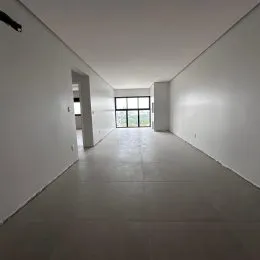 Corredor longo e claro com paredes brancas em uma residência.