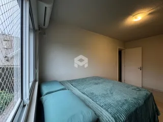 Quarto com janela e cama visível.
