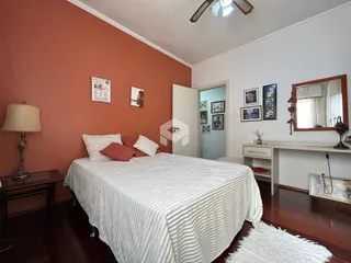 Quarto com cama e móveis de madeira em sala.