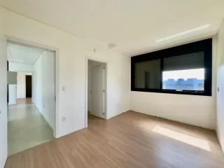 Foto de um ambiente interno com piso de madeira e uma grande janela.