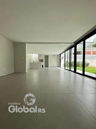 Vista interna de um ambiente moderno com piso de concreto e grandes janelas.